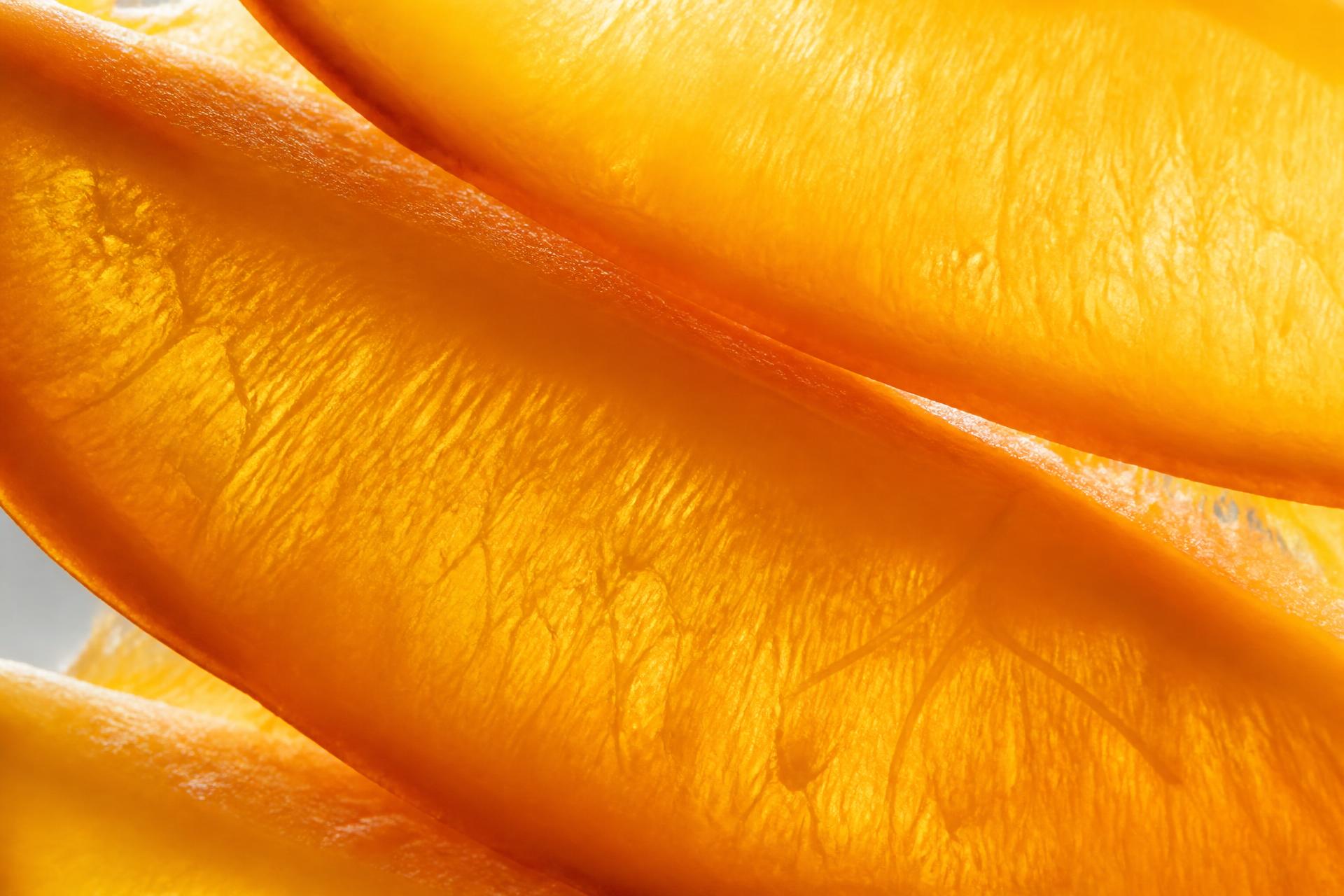 Close-up of golden mango, passionfruit and lime leaf on ceramic